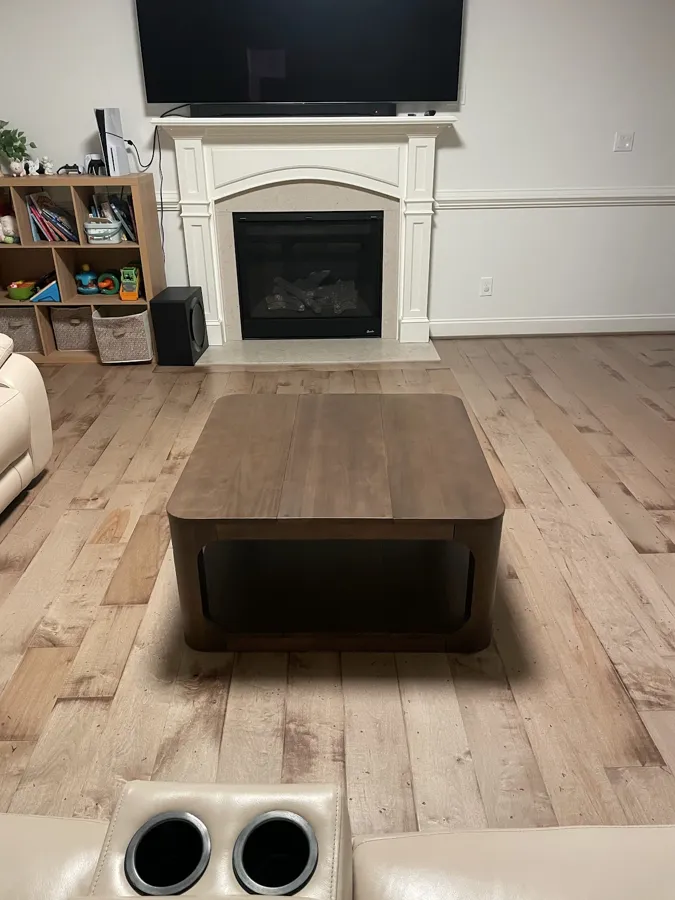 TV mounted above a white fireplace mantel in a living room with wood-look floors