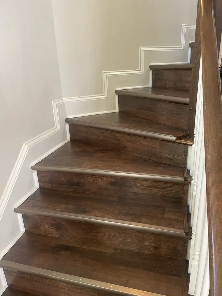 The same staircase with new wood-look plank treads and metal nosing